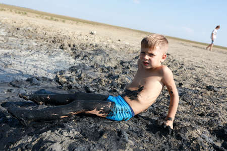 Child resting in medicinal mud, Krasnodar region, Russia