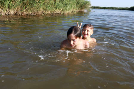 Two children swimming in lake, Krasnodar region, Russiaの写真素材