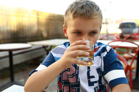 Child drinking lemonade in an outdoor restaurantの写真素材