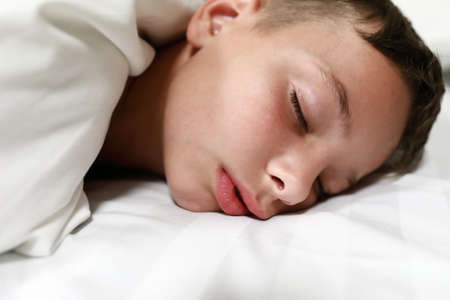 Boy sleeping on bed in the morning