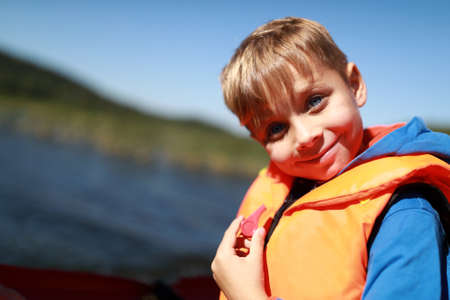 Kid in life jacket on boat in Ladoga skerriesの写真素材