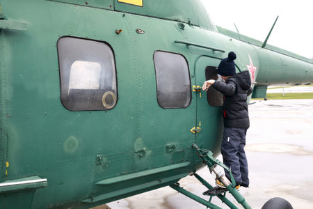 Boy looking out window of military helicopter Hoplite, Russiaの写真素材