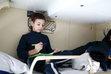 Child drawing on top shelf of train compartmentの写真素材