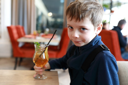 Portrait of kid drinking lemonade in cafeの写真素材