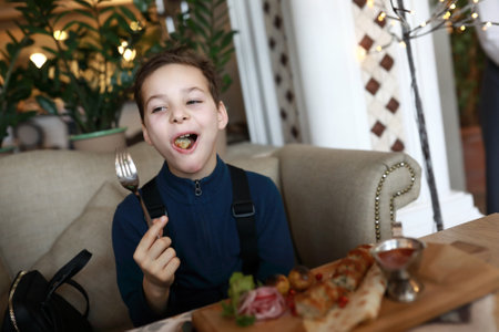 Boy eating lula kebab in a restaurant