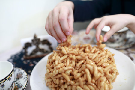 Children eating chak-chak dessert in tatar cafeの写真素材