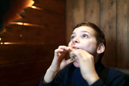 Portrait of child eating burger in restaurant