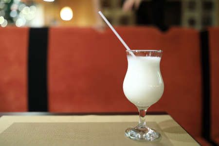 Glass of milk shake on table in restaurantの写真素材