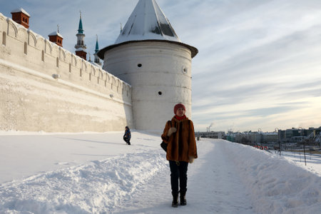 Woman on background of unnamed round tower of Kazan Kremlin in winter, Russiaのeditorial素材