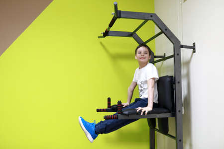 Child exercising on uneven bars in gym