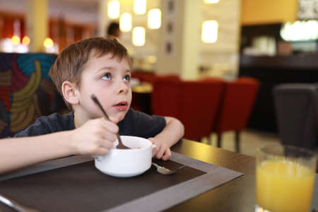 Portrait of kid has breakfast in restaurantの写真素材