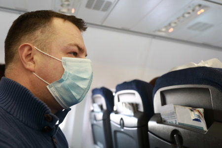 Portrait of man in medical mask on board aircraft