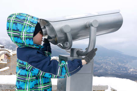 Child looking through binoculars on observation deck of Ai-Petri mountain peak in springの写真素材