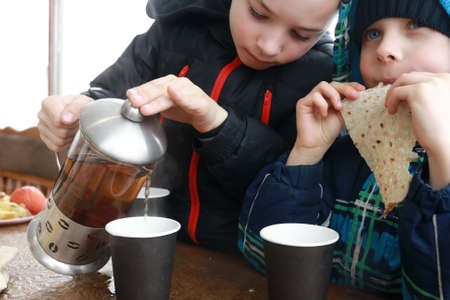 Child pouring herbal tea in a restaurantの写真素材