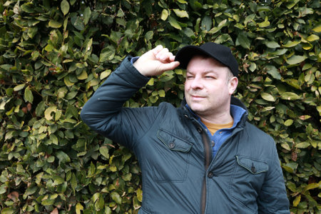 Man on background of laurel shrub in Nikitsky Botanical Garden, Crimea