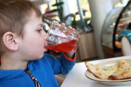 Portrait of boy drinking juice in cafeの写真素材