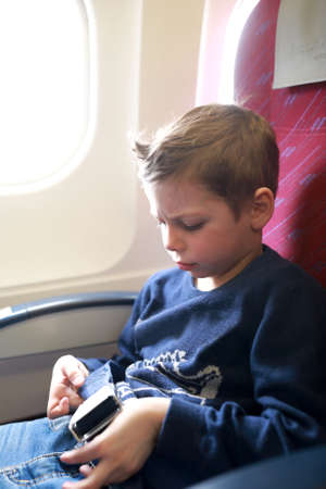 Portrait of Child Fastens Seat Belt on Airplane