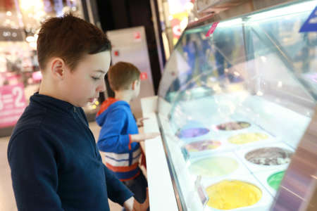 Two children choosing ice cream in storeの写真素材