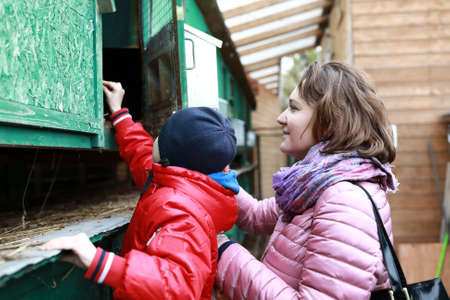 Mother with son feeding Rabbit on farm in spring