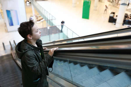 Portrait of child on escalator in mallの写真素材
