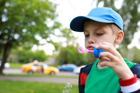 Child blowing soap bubbles in the parkの写真素材