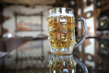Mug of lager on glass table in pubの写真素材