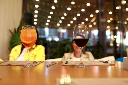 Glasses with aperol and wine on table in restaurantの写真素材