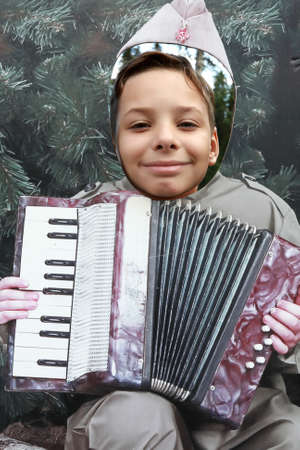 Boy peeping in hole of face of accordionist, Russia