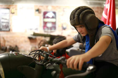 Boy on retro military motorcycle M-72 indoorの写真素材