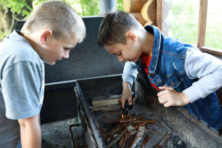 Two boys light fire on grill in gazebo, Kareliaの写真素材