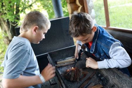 Two children light fire on grill in gazebo, Kareliaの写真素材