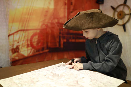 Portrait of boy in cocked hat examines mapの写真素材