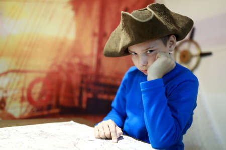 Portrait of child in cocked hat with mapの写真素材