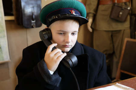 Portrait of child in uniform of border guard with telephone receiver