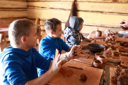 Three boys make clay crafts in workshopの写真素材