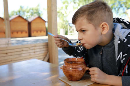Hungry kid eating pot roast in restaurantの写真素材