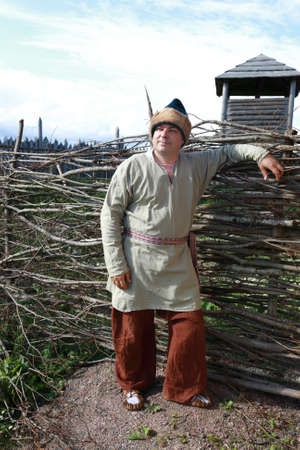 Man in Scandinavian folk clothes on background of fence, Kareliaの写真素材