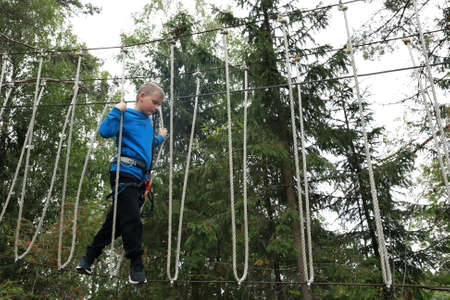 Boy passing obstacle course in forest, Kareliaの写真素材