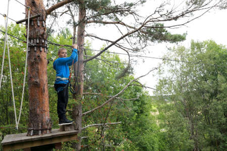 Serious boy overcomes obstacle course in rope parkの写真素材