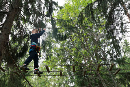 Kid overcomes obstacle course in forest, Kareliaの写真素材