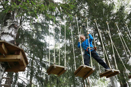 Kid overcomes obstacle course in rope parkの写真素材