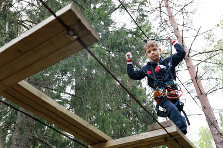 Serious child on obstacle course in rope park, Kareliaの写真素材