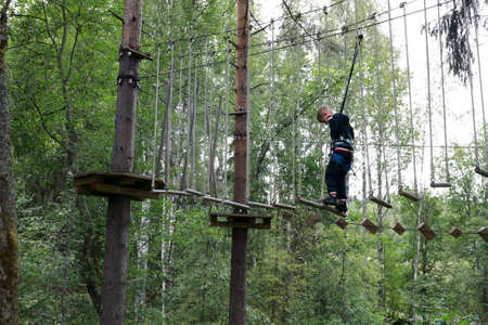 Kid passing obstacle course in forest, Kareliaの写真素材