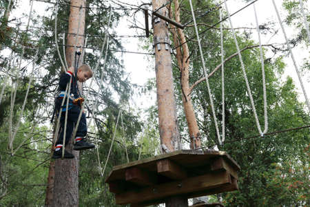 Serious boy passing obstacle course in rope park, Kareliaの写真素材