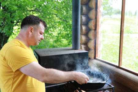 Man mixes boiling mushrooms in cauldron, Kareliaの写真素材