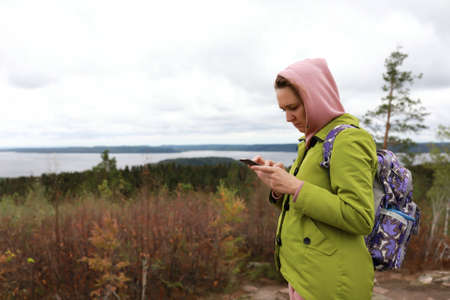 Woman with smartphone on Hiidenvuori mountain, Kareliaの写真素材