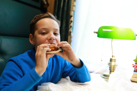Child eating burger in compartment of train carriage, Russiaの写真素材