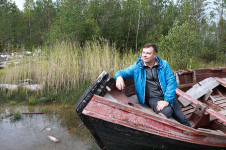 Man sitting in old wooden boat, Kareliaの写真素材