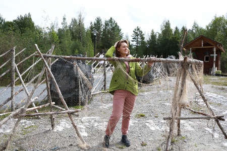 Woman next to old fishing nets hanging on wooden stand, Kareliaの写真素材