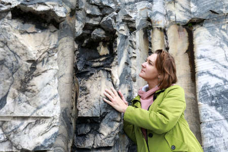 Woman touching marble wall in italian quarry, Ruskeala, Kareliaの写真素材